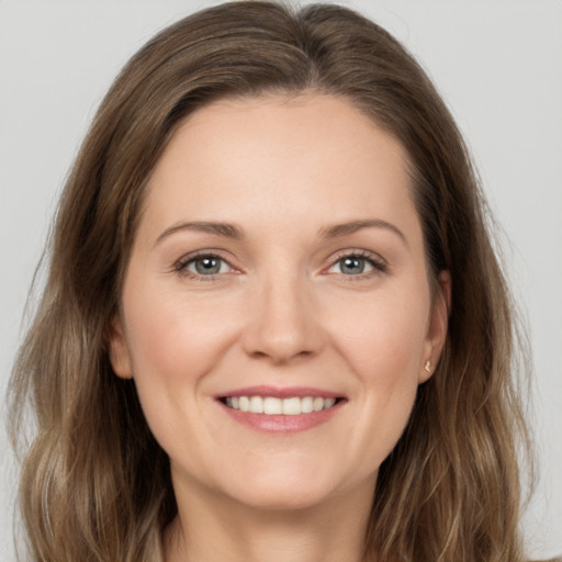 Joyful white young-adult female with long  brown hair and grey eyes