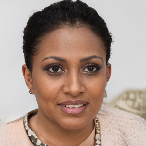 Joyful black young-adult female with short  brown hair and brown eyes