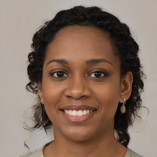 Joyful black young-adult female with medium  brown hair and brown eyes