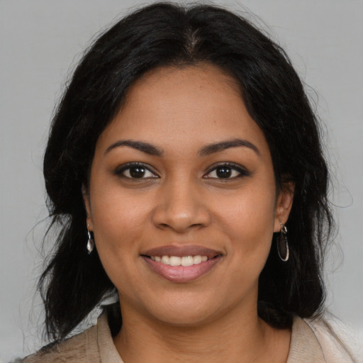 Joyful latino young-adult female with long  brown hair and brown eyes