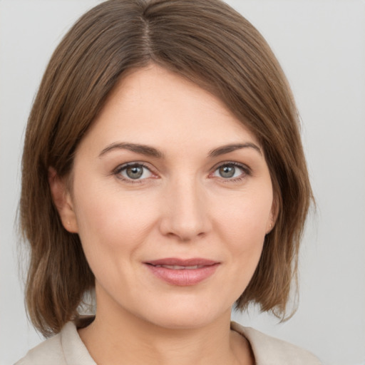 Joyful white young-adult female with medium  brown hair and grey eyes