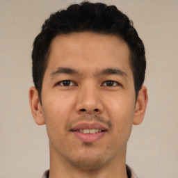 Joyful latino young-adult male with short  brown hair and brown eyes