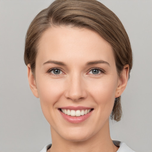 Joyful white young-adult female with short  brown hair and grey eyes