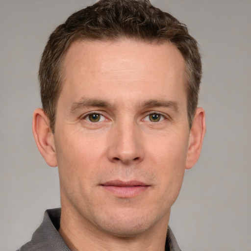 Joyful white adult male with short  brown hair and grey eyes