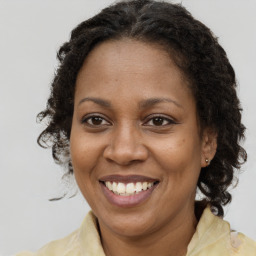 Joyful black adult female with medium  brown hair and brown eyes