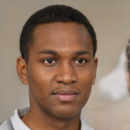 Joyful black young-adult male with short  brown hair and brown eyes