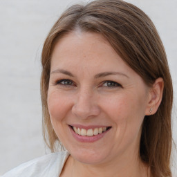 Joyful white adult female with medium  brown hair and grey eyes