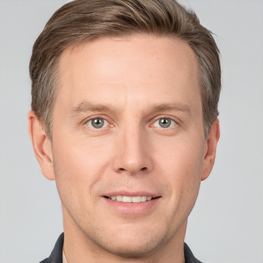 Joyful white adult male with short  brown hair and grey eyes