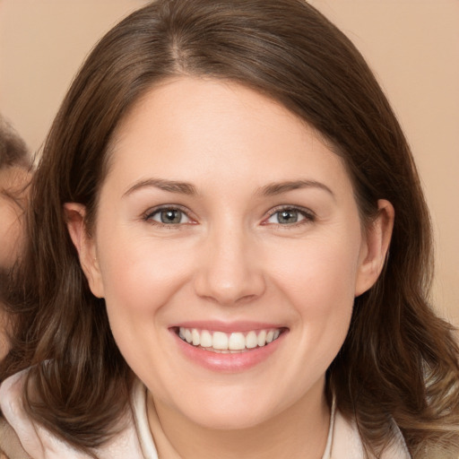 Joyful white young-adult female with long  brown hair and brown eyes