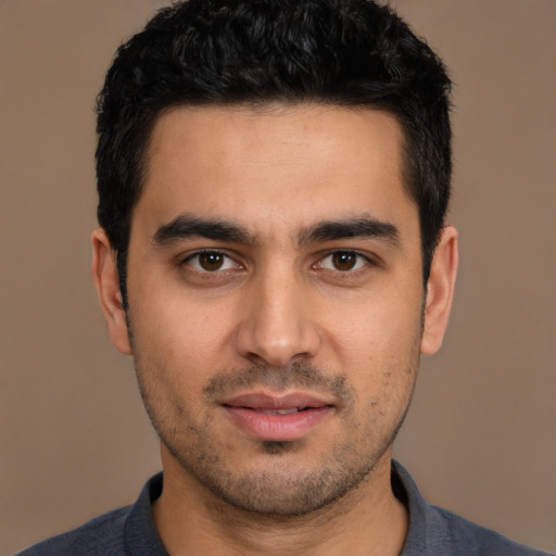 Joyful white young-adult male with short  black hair and brown eyes