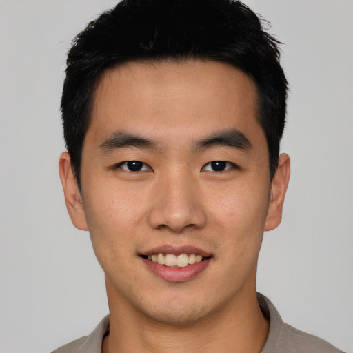 Joyful asian young-adult male with short  black hair and brown eyes