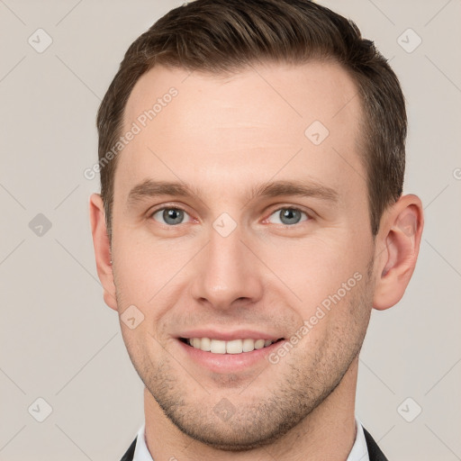 Joyful white young-adult male with short  brown hair and grey eyes