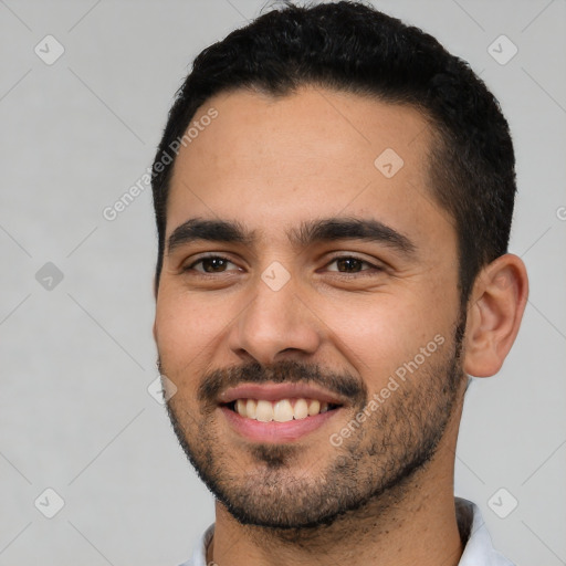 Joyful latino young-adult male with short  black hair and brown eyes