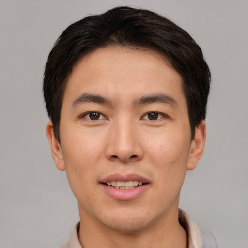 Joyful asian young-adult male with short  brown hair and brown eyes