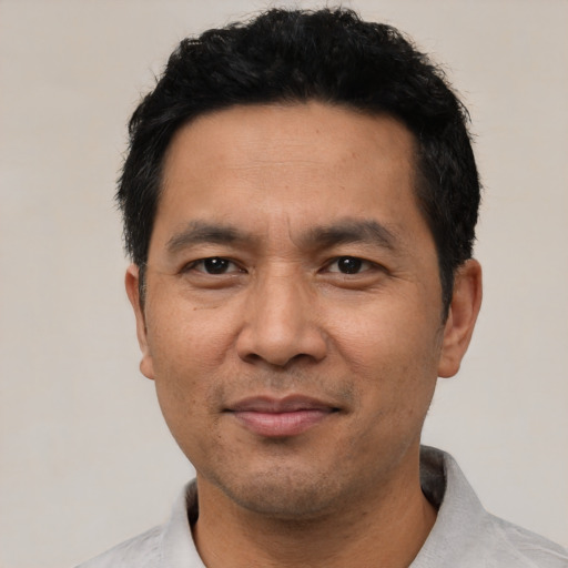 Joyful asian adult male with short  black hair and brown eyes