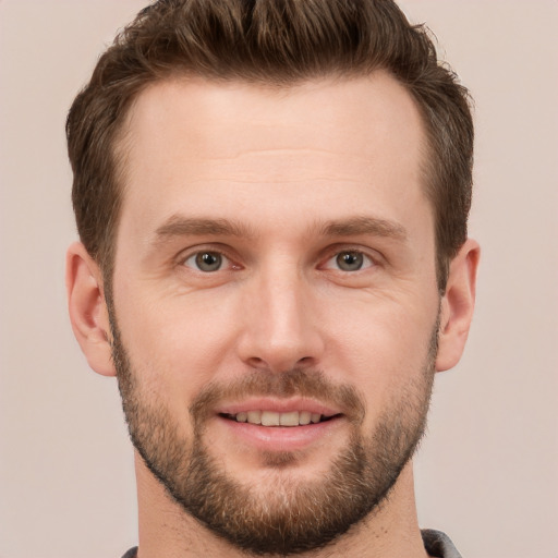 Joyful white young-adult male with short  brown hair and grey eyes