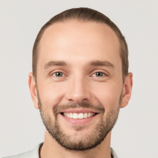 Joyful white young-adult male with short  brown hair and grey eyes