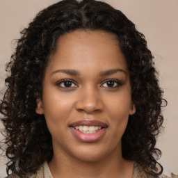 Joyful black young-adult female with long  brown hair and brown eyes