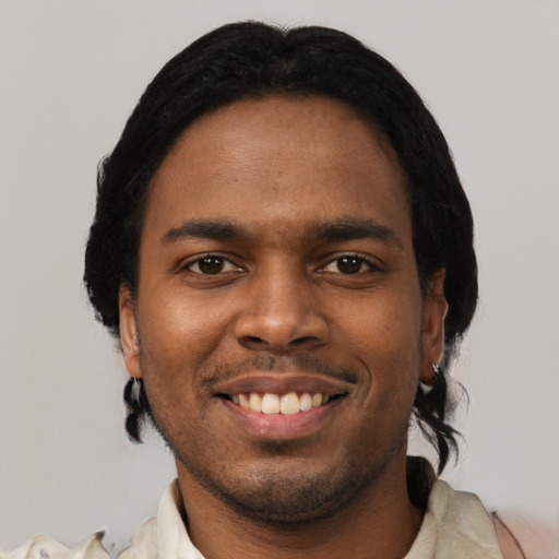 Joyful black young-adult male with short  black hair and brown eyes