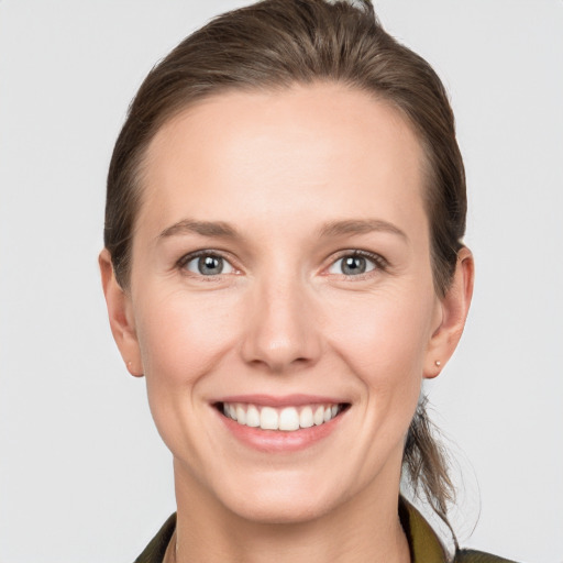 Joyful white young-adult female with medium  brown hair and grey eyes