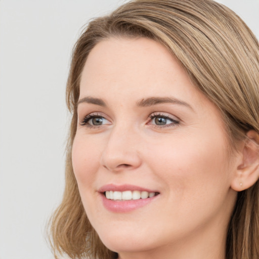 Joyful white young-adult female with long  brown hair and blue eyes