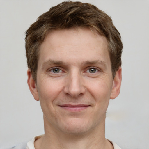 Joyful white adult male with short  brown hair and grey eyes