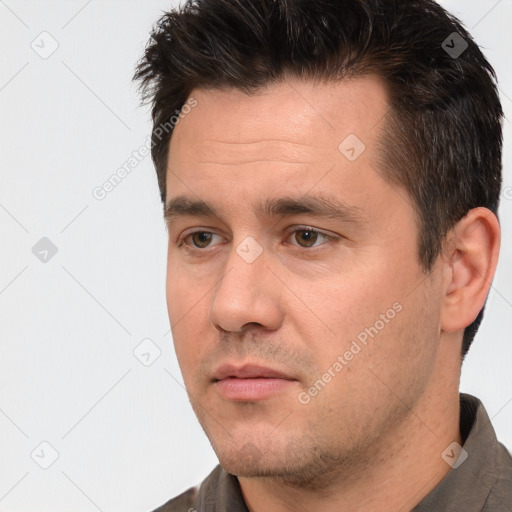 Joyful white adult male with short  black hair and brown eyes