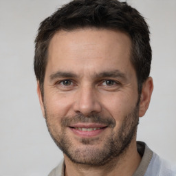 Joyful white adult male with short  brown hair and brown eyes