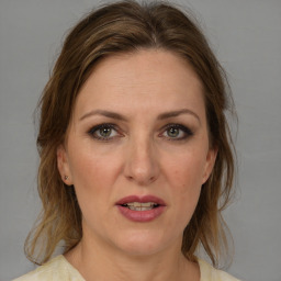 Joyful white adult female with medium  brown hair and grey eyes