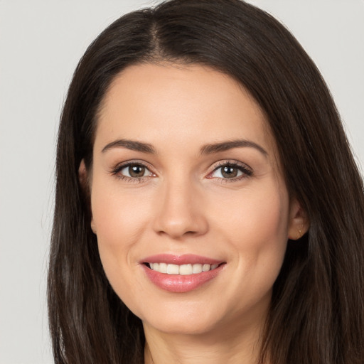 Joyful white young-adult female with long  brown hair and brown eyes