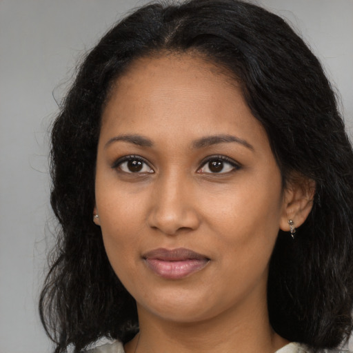 Joyful black young-adult female with long  brown hair and brown eyes