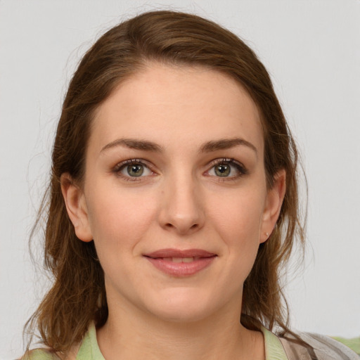 Joyful white young-adult female with medium  brown hair and green eyes