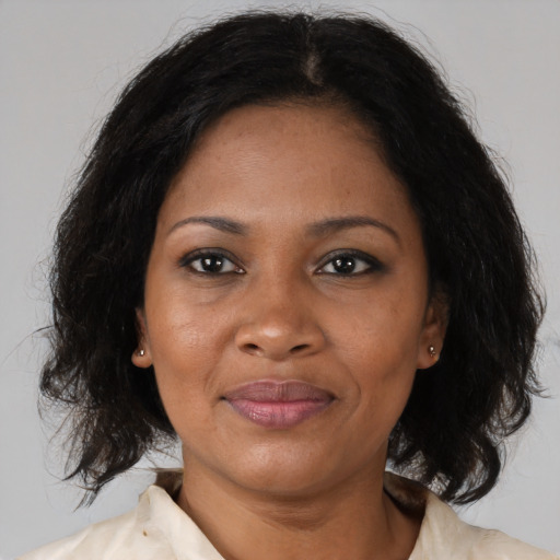 Joyful black adult female with medium  brown hair and brown eyes
