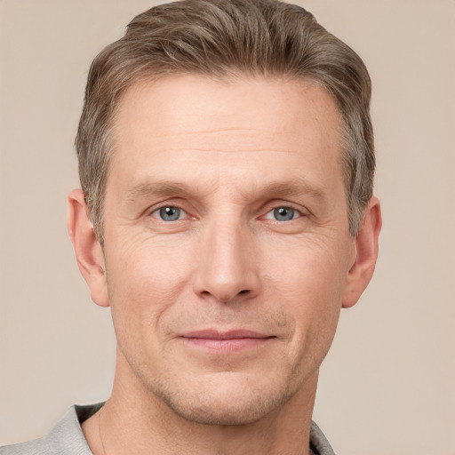 Joyful white adult male with short  brown hair and grey eyes