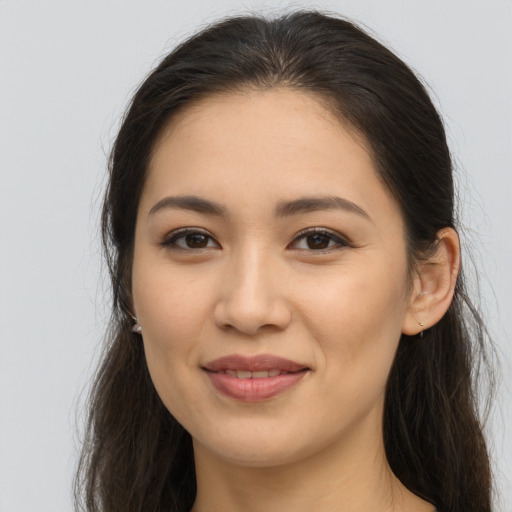 Joyful latino young-adult female with long  brown hair and brown eyes