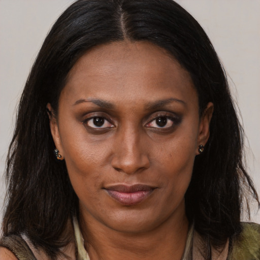 Joyful black adult female with long  brown hair and brown eyes