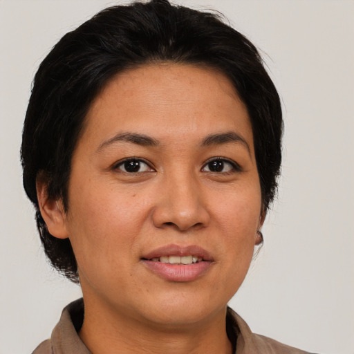 Joyful asian adult female with medium  brown hair and brown eyes
