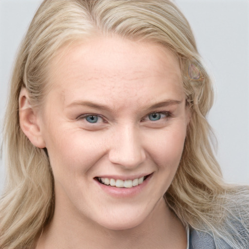 Joyful white young-adult female with long  blond hair and blue eyes