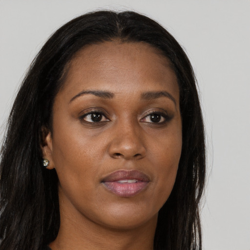 Joyful black young-adult female with long  brown hair and brown eyes