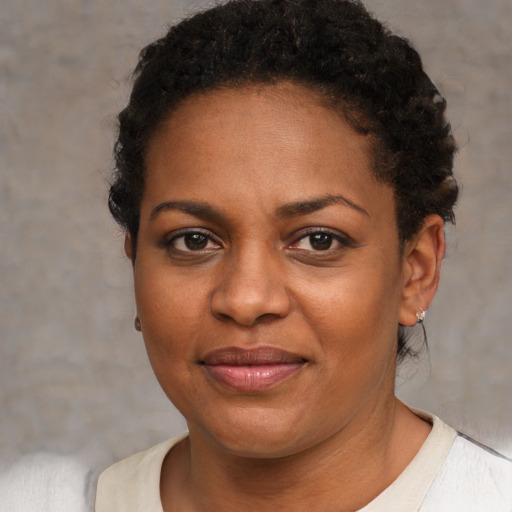 Joyful black young-adult female with short  brown hair and brown eyes