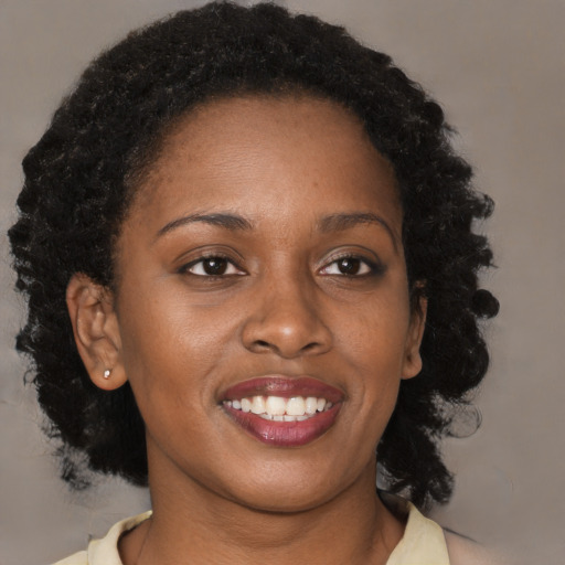 Joyful black young-adult female with medium  brown hair and brown eyes