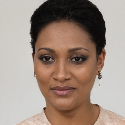 Joyful black young-adult female with short  black hair and brown eyes