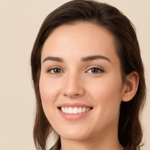 Joyful white young-adult female with long  brown hair and brown eyes