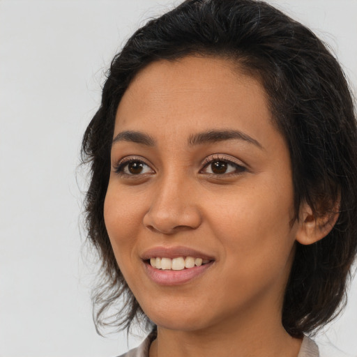 Joyful latino young-adult female with medium  brown hair and brown eyes