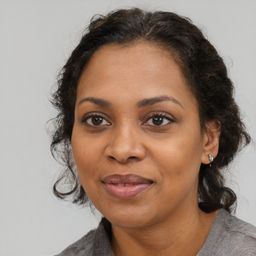Joyful black adult female with medium  brown hair and brown eyes