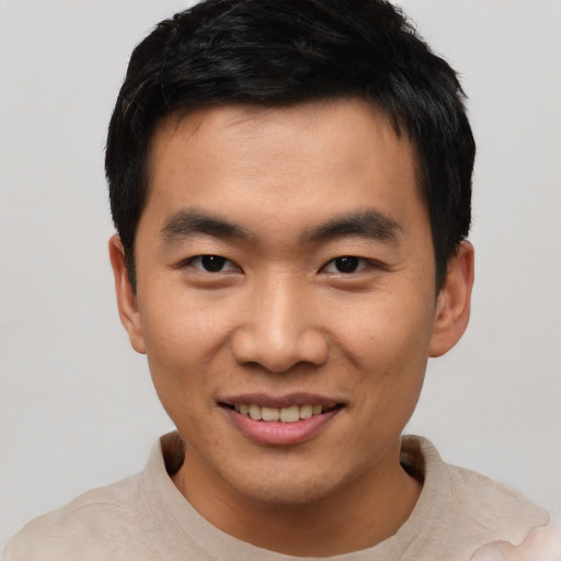 Joyful asian young-adult male with short  black hair and brown eyes