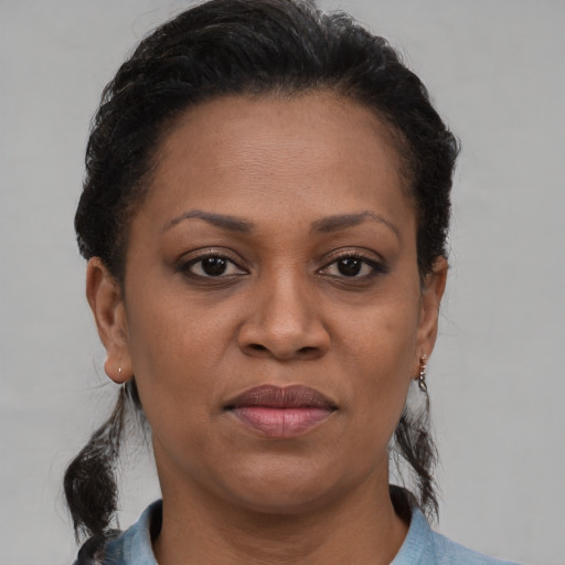Joyful latino adult female with medium  brown hair and brown eyes