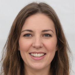 Joyful white young-adult female with long  brown hair and green eyes