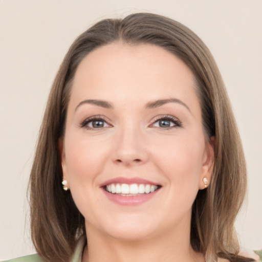 Joyful white young-adult female with medium  brown hair and grey eyes