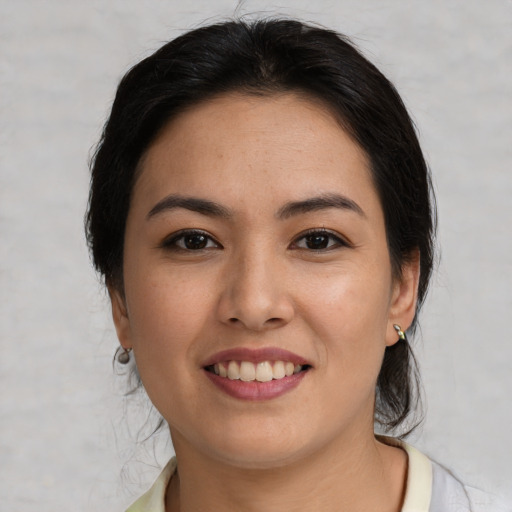 Joyful latino young-adult female with medium  brown hair and brown eyes